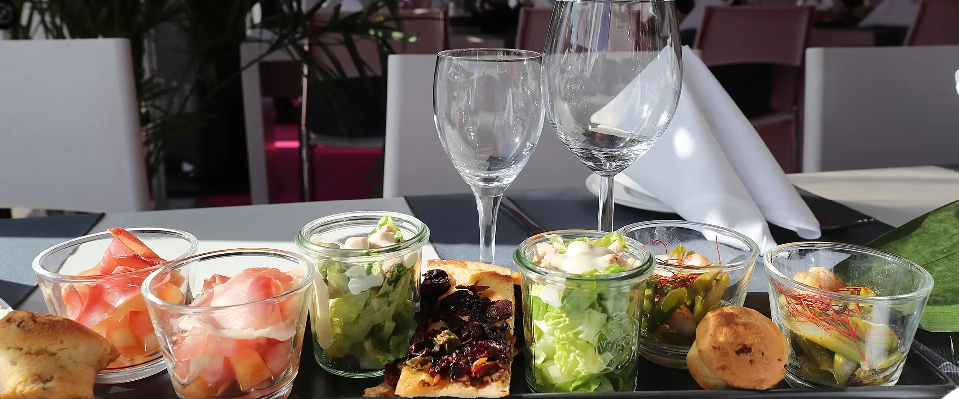 Cateringtablett mit Speisen in kleinen Gläsern dekorativ angerichtet